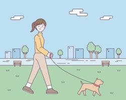 A woman is taking a walk in a park in the city center with her dog. vector