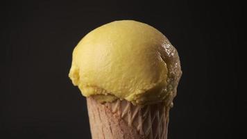 Rotazione a 360 gradi di un delizioso cono gelato al mango. concetto di dolce e dessert. video