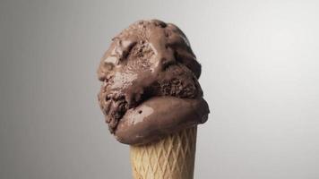 Cono de helado de chocolate que se derrite gradualmente sobre un fondo aislado. lapso de tiempo 4k video