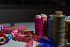 Blurred background of multicolored threads and sewing accessories. photo