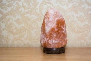 Pink salt lamp on the table in the bedroom photo