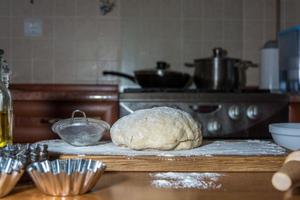 Masa casera recién mezclada para hornear pan en la mesa de la cocina foto