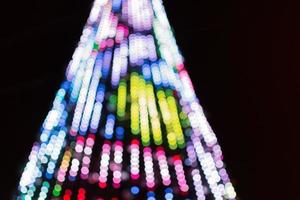 Glare from garlands on the Christmas tree. Soft blur with bokeh photo