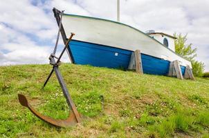 Boat with heavy anchor on grass photo