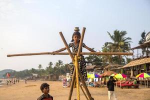 anjuna, india, 14 de octubre de 2015 - niña de goa no identificada en la cuerda floja en la playa de anjuna. foto