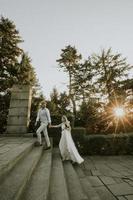 Joven pareja de recién casados caminando por las escaleras en el parque