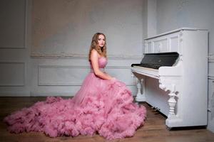 portrait of young beautiful woman in long pink dress photo