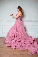 portrait of young beautiful woman in long pink dress photo