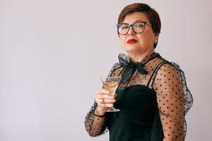 stylish mature senior woman with glass of wine. Fun, party, style, lifestyle, work, alcohol, celebration concept photo