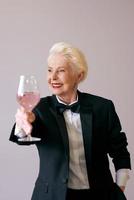 elegante sommelier madura mujer senior en esmoquin con copa de vino. diversión, fiesta, estilo, estilo de vida, trabajo, alcohol, concepto de celebración