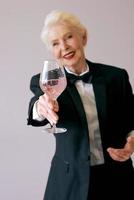 elegante sommelier madura mujer senior en esmoquin con copa de vino. diversión, fiesta, estilo, estilo de vida, trabajo, alcohol, concepto de celebración