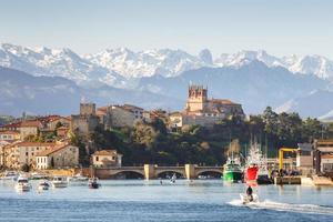 San Vicente de la Barquera, Cantabria, Spain, 19 10 2021, View of the famous tourist town of San Vicente de la Barquera on a sunny day with moored fishing boats photo
