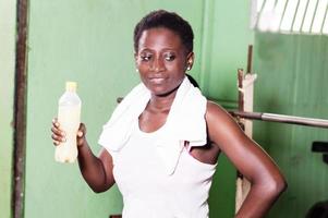 Smiling young woman holding a bottle of fruit juice. photo