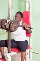 mujer joven levantando pesas en el gimnasio. foto