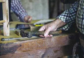 Carpenter's hand holding a hammer photo