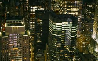 Ventanas de rascacielos iluminados por la noche en Manhattan foto