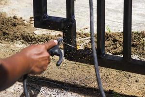 A worker is welding iron without wearing gloves. Light welding work. photo