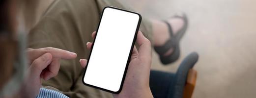 Mockup image blank white screen cell phone.women hand holding texting using mobile on desk at home office. photo