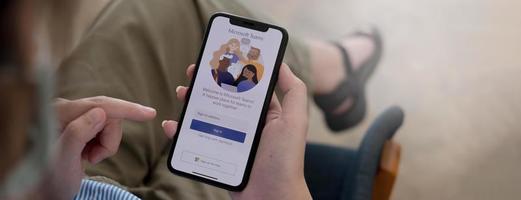 A working from home employee is downloading the Microsoft Teams social platform, ready for remote working in isolation from home photo