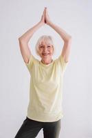 mujer mayor haciendo yoga en el interior. anti edad, deporte, concepto de yoga foto