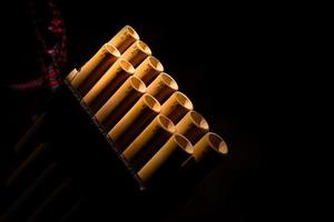 Detail of a pan flute on a black background photo