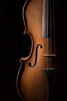 Detalle de violín artesanal sobre un fondo negro foto
