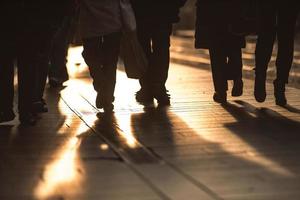 Detail of people walking on the sidewalks of a city photo