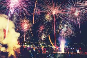 fondo festivo año nuevo con fuegos artificiales y bokeh. Fuegos artificiales de año nuevo en la playa. foto