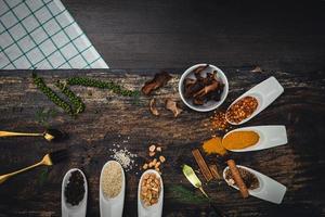 Various colorful herbs and spices on wooden table. Top view of spices and herbs. Spices and herbs over on wooden table background. photo