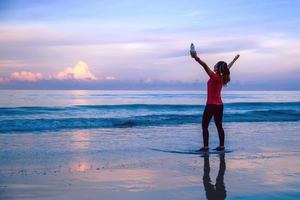 Girl running workout jogging on the beach in the morning. relax and happy with running on the sea. in summer photo