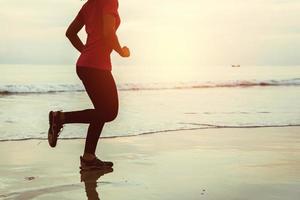 Woman jogging workout on the beach in the morning. Relax with the sea walk. photo