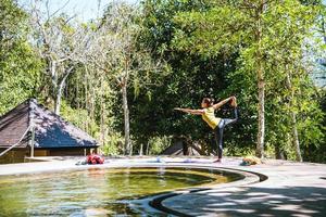 las mujeres asiáticas se relajan en las vacaciones. jugar si yoga en la piscina de aguas termales, relajarse en un ejercicio de postura de aguas termales naturales. foto