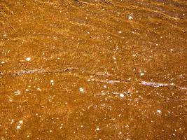 Light reflection on the surface of movement sea on sand beach photo