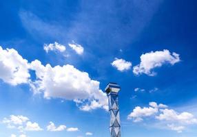 Shiny steel smokestack and cloud in sky photo