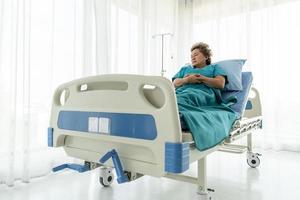 Senior patients that need treatment being alone in a patient's bed with sad emotions. photo