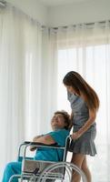 Daughter of a senior patient taking care and encouraging the mother after receiving treatment from the doctor. photo