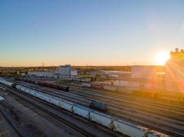 Vista aérea del patio ferroviario al atardecer con rayos relucientes foto