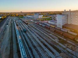 aerial view of rail yard switching station and urban buildings at sunset
