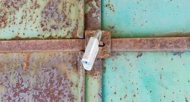 metal door with lock, texture and background. Background texture of an iron padlock on a rusty metal gate. photo