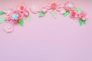 Different pink paper flowers on pink background photo