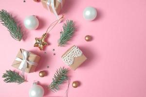 Christmas background with decorations and gift boxes on pink background photo