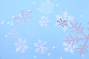 fondo de invierno. copos de nieve blancos cortados de papel blanco sobre un fondo azul. foto