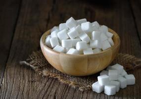 Sugar cubes in wood bowl on wood table