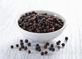 black pepper in bowl on white background photo