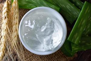 aloe vera gel in bowl with on wooden table photo