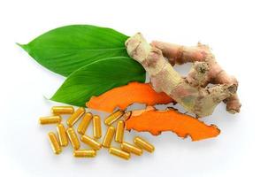 Turmeric and turmeric capsules on white background photo