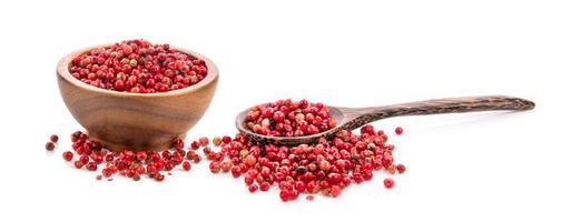 dried pink peppers in wood bowl isolated on white background photo