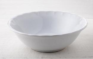 Empty white ceramic bowl on white wood photo