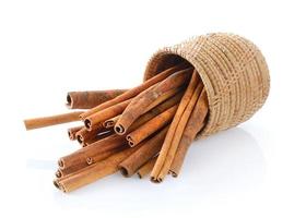 Cinnamon in basket on white background photo