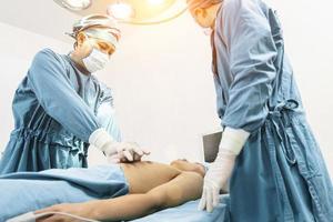 surgeon and assistant making CPR on the patient in the operating room. First Aid Emergency- Cardiopulmonary resuscitation photo